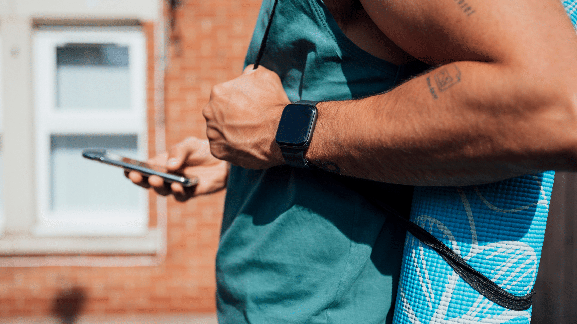 Picture of a man in a blue shirt wearing fitness gear, reading his mobile phone. Image is used for blog titled, "Newswire Helps Land Wall Street Journal Feature for Tech Industry Client"