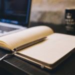 Image of an open laptop and open notebook. Image used for a blog post about building brand authority.