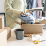 Image of a lady packing a piece of clothing into a shipping box. Image is being used for a product launch press release blog.