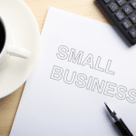 Picture of a white coffee cup filled with black coffee and a white sheet of paper that reads "small business." Image is used for a blog post about Small Business Saturday.