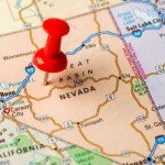 Picture of a map with a red push pin in the state of Nevada. Image is being used for a Newswire blog post about the top media outlets in Nevada.