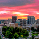 Picture of downtown Boise with a beautiful pink, yellow, and orange sky. This image is being used for a Newswire blog post about the top media outlets in Idaho.