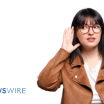 Picture of a lady in a brown suede coat holding her hand up to ear as if she's listening. This image is being used for a Newswire blog about Media Monitoring.