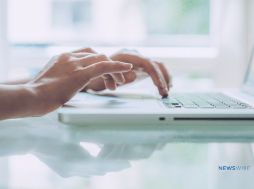 Picture of a woman's hands typing on a laptop.