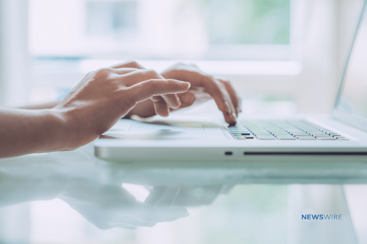 Picture of a woman's hands typing on a laptop.