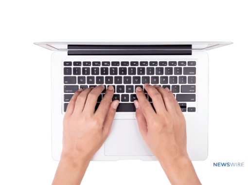 Picture of a woman's hands typing on a Macbook.